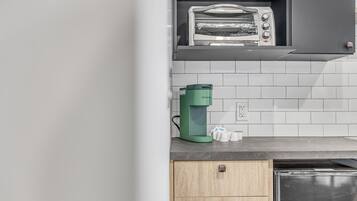 Eine Küche mit integriertem Toaster, einer Keurig-Kaffeemaschine und einem Geschirrspüler.
