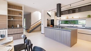 A modern kitchen with a central island, built-in shelving, and a large window overlooking greenery. - Villa Optima by Villa Plus (Ionian Islands)