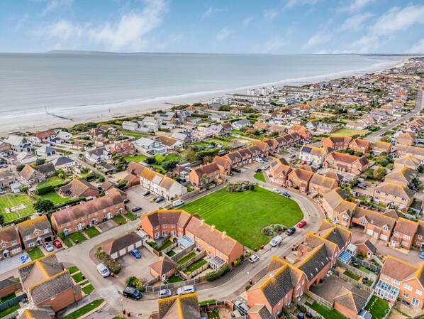Vista aérea de una zona residencial costera con casas, carreteras y una playa.