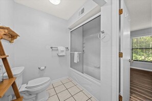 A bathroom with a toilet, a glass-enclosed shower, and a wooden shelf. - 2nd Floor 1BR/2BA High Hammock Villa! Amenity access NOT permitted (Seabrook Island)