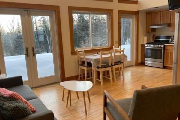 Open living room with french doors, huge windows & vaulted ceiling