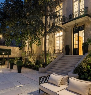A courtyard with a sofa, steps leading to a building entrance, and potted plants. - HIGHSTAY - Luxury Serviced Villa - Poincaré (Paris)