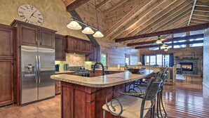 Una cocina amplia con una isla grande, armarios de madera y un refrigerador empotrado.