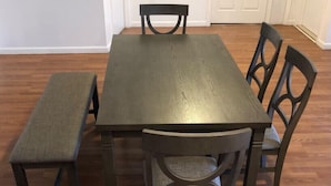 Una mesa de comedor con cuatro sillas y un banco.