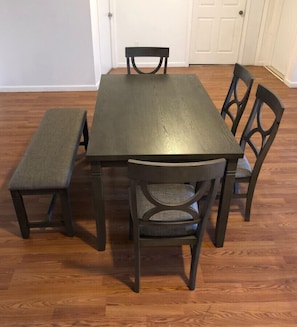 A dining table with four chairs and a bench.