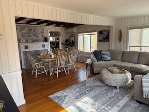 A spacious living area with a dining table, chairs, a sofa, and a patterned rug. - Charming, freshly updated 3-bedroom house in superb Ocean Beach (Ocean Beach)