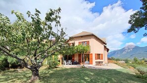 A two-story house with a patio, surrounded by greenery and mountains. - Spacious apartment with magnificent view and terrace, on the 1st floor of a villa. (EMBRUN)