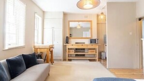 A bedroom with a bed, a desk, and a mirror. - PBC | Studio Apartment by Sloane Square - FDP (London)