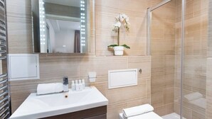 Une salle de bain moderne avec un meuble-lavabo, un miroir et une douche.