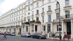 A row of white townhouses with balconies, parked cars, and a sign indicating 'Princes Square W2'. - PBC | Large Studio w/Patio in Bayswater (LS4) (London)