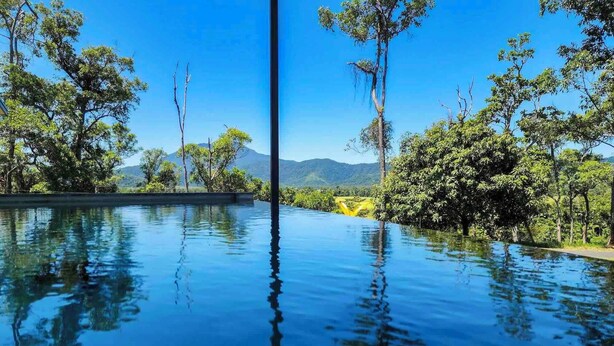 An infinity pool with a clear view of surrounding trees and distant mountains. - Daintree Getaway is a secluded holiday home nestled in a private oasis (Lower Daintree)