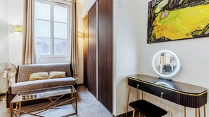 A modern room with a sofa, a vanity with a mirror, and a large abstract painting on the wall. - Spacious loft Luxembourg Garden (Paris)