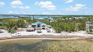 A beachfront property with a large house, a pool, and a clear view of the ocean and islands in the distance. - Star Room Barnacle Resort (Big Pine Key)