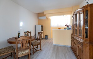 Cozy living space with a dining area, cabinet, kitchenette, and natural light.