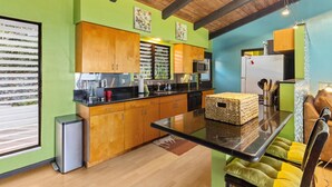 Una cocina moderna con armarios de madera, encimera negra y microondas integrado.