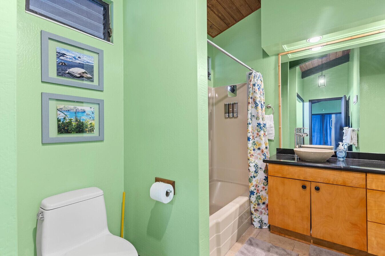 Une salle de bain équipée de toilettes, d’un lavabo, d’une baignoire et d’un rideau de douche.