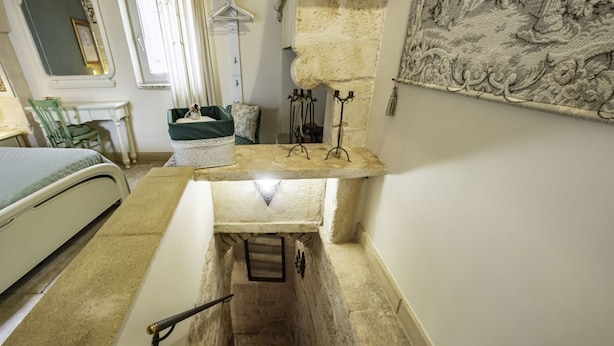 A narrow stairway leading to a lower level with a small window and a metal railing. - A Casa di Marilù by Rentbeat (Martina Franca)