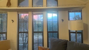 Una habitación con ventanas amplias, un sofá y una lámpara.