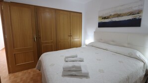 Ein Schlafzimmer mit einem großen Bett, einem Holzschrank und einem Gemälde an der Wand.