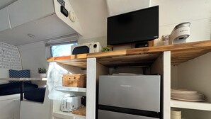 A compact kitchen with a Hisense refrigerator, a microwave, and a Keurig coffee maker.