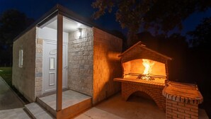 Un petit bâtiment en briques doté d’une cheminée, d’une porte et d’un luminaire.