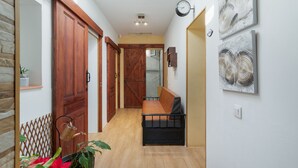A hallway with wooden doors, a bench, and wall art.