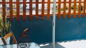 An outdoor seating area with a table, chairs, and a lantern.