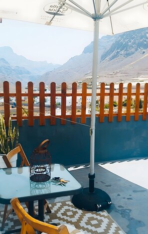 Un espace extérieur aménagé avec une table, des chaises et une lanterne.