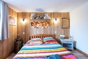A wooden-paneled room with a bed, a shelf with stuffed animals, and a wall-mounted light fixture. - Holiday Home 'D'Aillon' with Mountain Views, Private Terrace, and Wi-Fi (Aillon-le-Jeune)