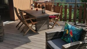 A wooden deck with outdoor furniture, including a table and chairs, and a large umbrella providing shade. - Holiday Home 'D'Aillon' with Mountain Views, Private Terrace, and Wi-Fi (Aillon-le-Jeune)