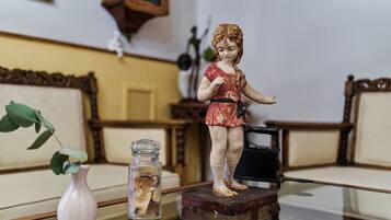 Une figurine posée sur une table, un vase avec une plante et un objet décoratif accroché au mur.