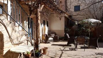 A courtyard with outdoor seating, potted plants, and a staircase.