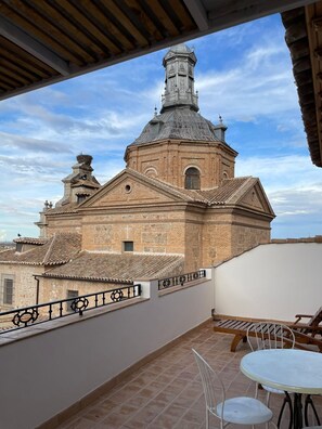 A terrace with a view of a historic building with a bell tower, a tiled roof, and a white railing. - Library Studio in Consuegra, Land of Don Quixote (Consuegra)