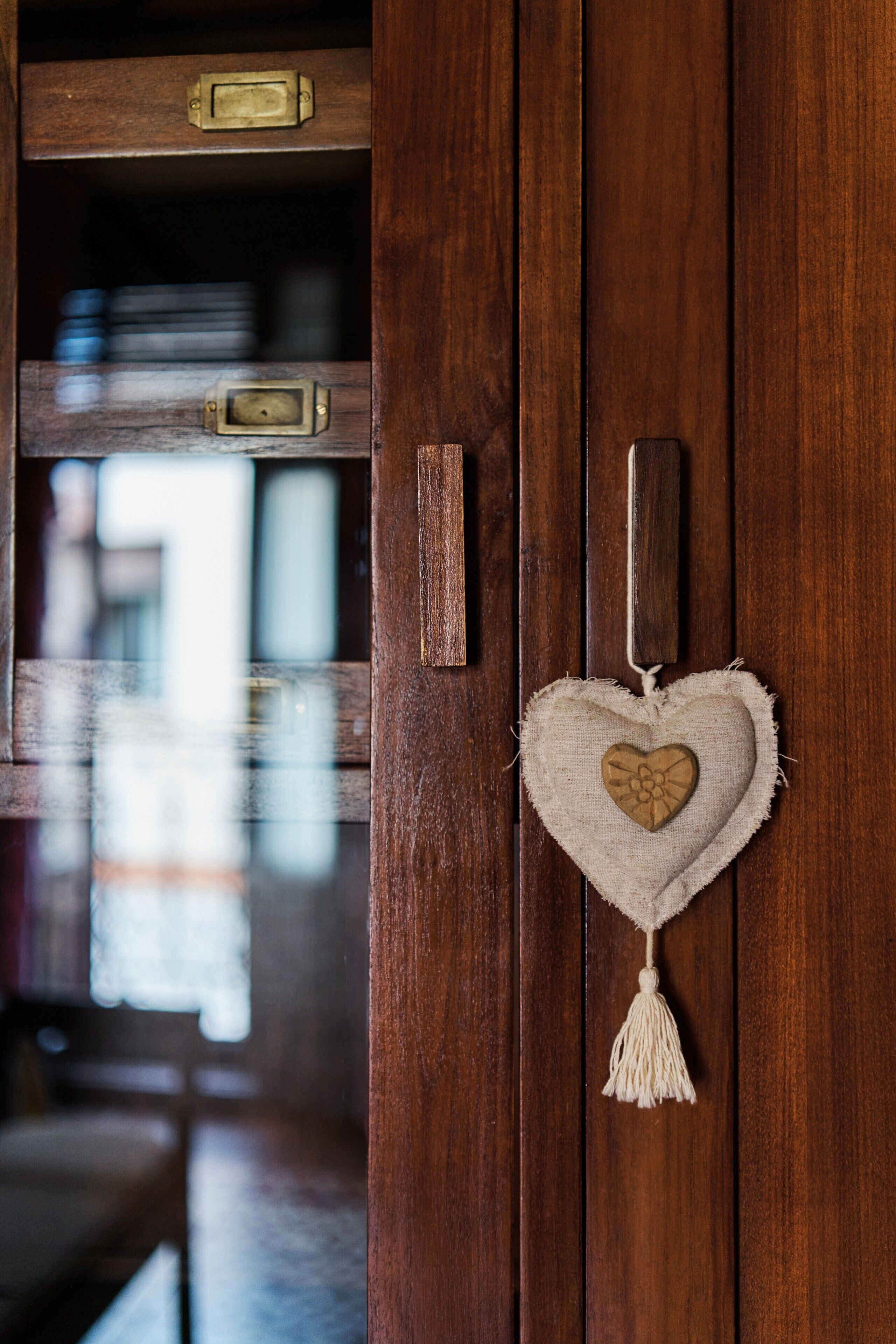 A wooden door with a heart-shaped decoration and a tassel.