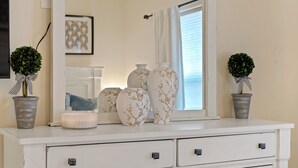 A white dresser with three vases, a candle, and two potted plants. - Desert Haven Townhome – Comfort, Style & Prime Tubac Location (Tubac)