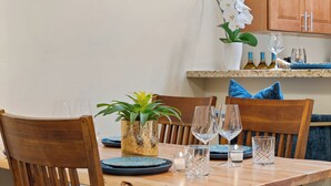 A dining table set with plates, glasses, and a decorative plant. - Desert Haven Townhome – Comfort, Style & Prime Tubac Location (Tubac)