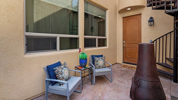 A patio area with two chairs, a decorative planter, and a staircase. - Desert Haven Townhome – Comfort, Style & Prime Tubac Location (Tubac)