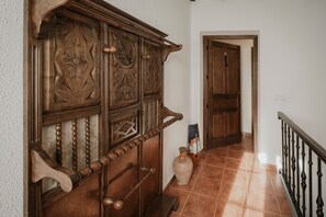 A wooden staircase with a handrail, a vase, and a door at the top.