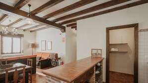 Une cuisine dotée d’un long comptoir, de chaises en bois, d’une table à manger et d’un mur décoratif en briques.