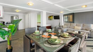 A dining area with a glass table set for six, surrounded by wicker chairs. - Apartment 'The Wave House - Seaside Haven' with Sea View, Wi-Fi and Air Conditioning (Jardim do Mar)