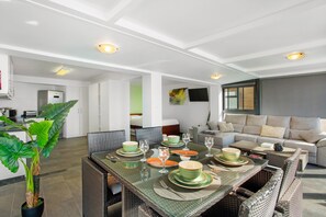 A dining area with a glass table set for six, surrounded by wicker chairs. - Apartment 'The Wave House - Seaside Haven' with Sea View, Wi-Fi and Air Conditioning (Jardim do Mar)