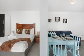 A bedroom with a bed, bedside table, and a nightstand.