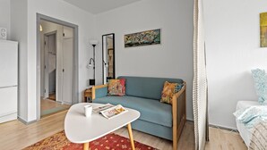 Un salon moderne avec un canapé, une table basse et un tableau accroché au mur.