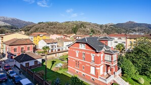 A residential area with houses, a street, and a mountain in the background. - Apartment 'Comarca Del Sella' with Mountain View and Wi-Fi (Arriondas)