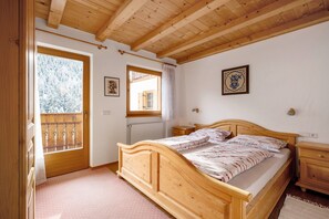 A wooden-framed bedroom with a bed, a window, and a radiator. - Apartment 'Heinzenhof  2' with Mountain View, Shared Garden and Wi-Fi (Welschnofen)