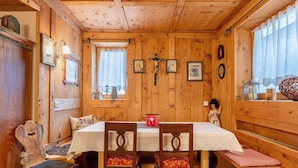 Um interior de madeira com uma mesa de jantar, cadeiras e um banco.