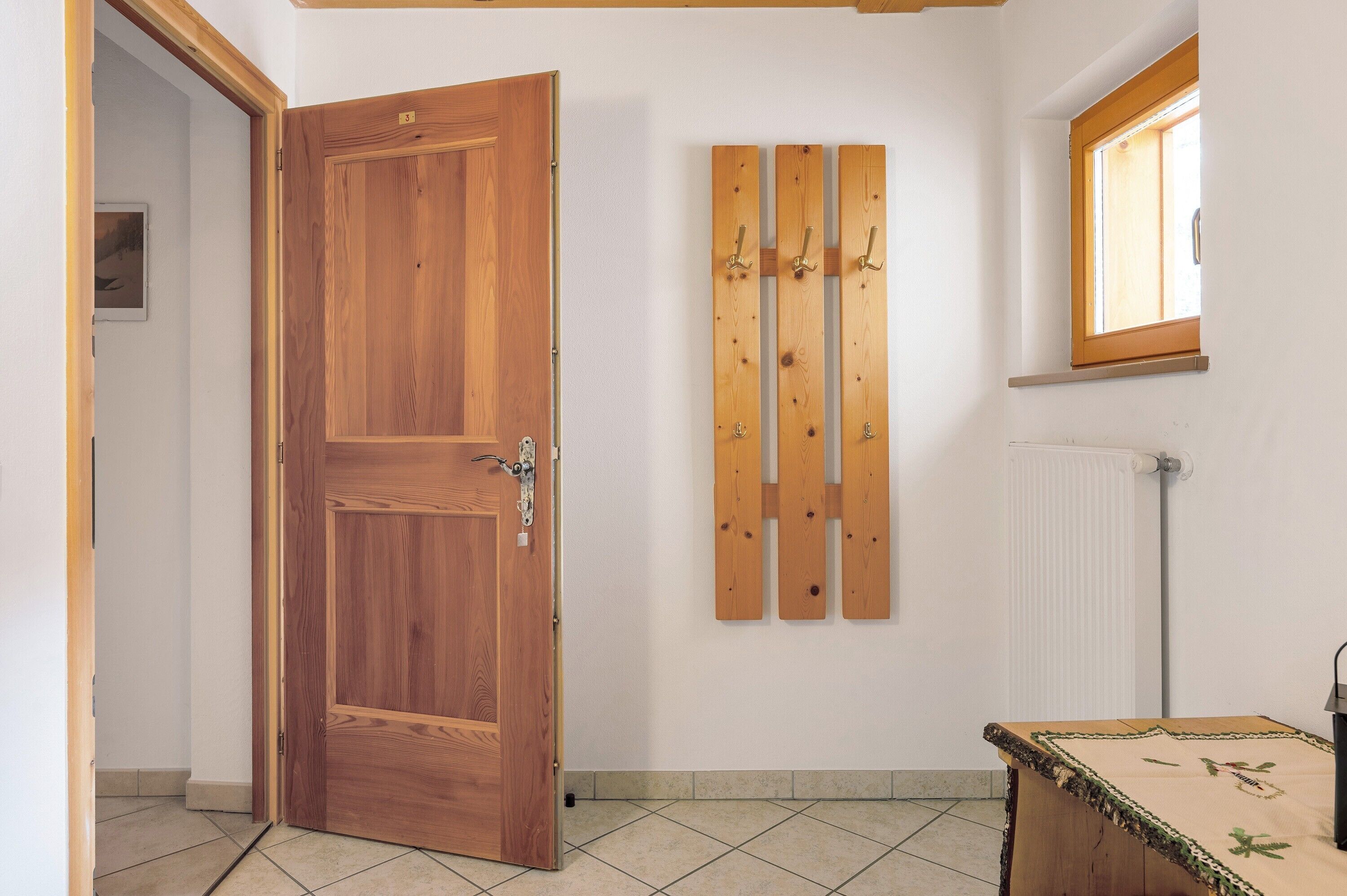 A wooden door, a radiator, and a window with a wooden frame.