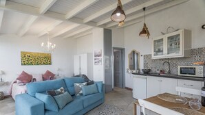 Une cuisine moderne avec des meubles blancs, un four à micro-ondes et un coin repas comprenant une table et des chaises.
