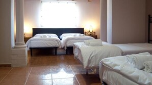 Habitación de hotel con dos camas, techo de madera y un ventanal grande.
