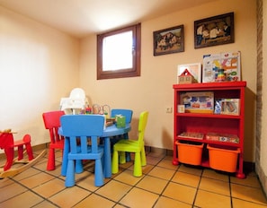 A children's play area with a table, chairs, and a bookshelf.